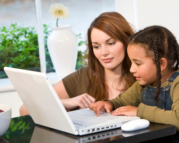 Parent using laptop with child